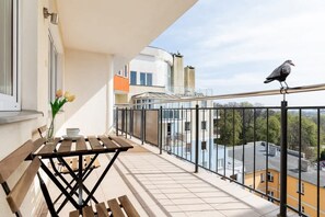 A private balcony with a table and chairs, providing a relaxing space to enjoy the view over the surrounding neighborhood.
