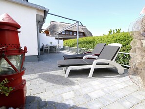 bestuhlte Terrasse mit Sonnenliegen