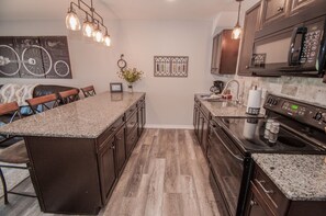 Kitchen includes plenty of cookware, dishes and utensils.