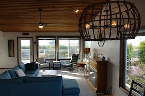 Living room leads to a large westside deck, perfect for sunset gatherings.