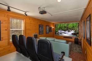 Theater room with 8 re purposed theater seats and a sofa bed for extra seating. Projector with DVD player and PS4
