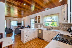 Kitchen showing living room, large windows and red cedar wood ceiling & internet
