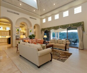 Spacious living room opening through glass doors to outdoor terrace

