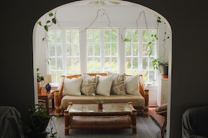 Attached sunroom with panaramic windows, additional seating, and lots of plants