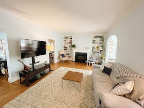 Living room with a couch, coffee table, chairs, and entertainment center.