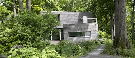 the passive haus sits on a ledge amongst 100 year old oaks
