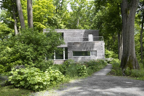 the passive haus sits on a ledge amongst 100 year old oaks
