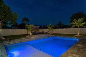 Evening view of pool and trees with up lights