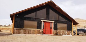 Front of Lodge. New Paint, trim, and Vegas lighting coming spring 2025. Urban legend has it that the big red door was reclaimed from Harrison Ford's ranch in Wilson, Wyoming.