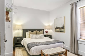 The master bedroom offers a queen size bed with white, cotton bedding, and down duvet. Attached is an ensuite bathroom.