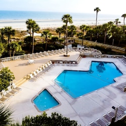 Large pool with kids pool and eating area with gas grills across the street
