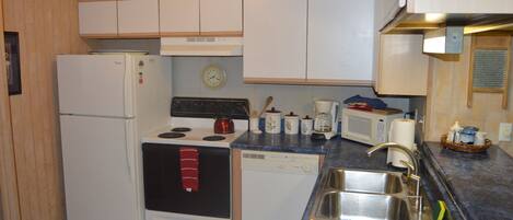 Fully functioning kitchen with fridge, stove and oven, dishwasher, kitchen ware