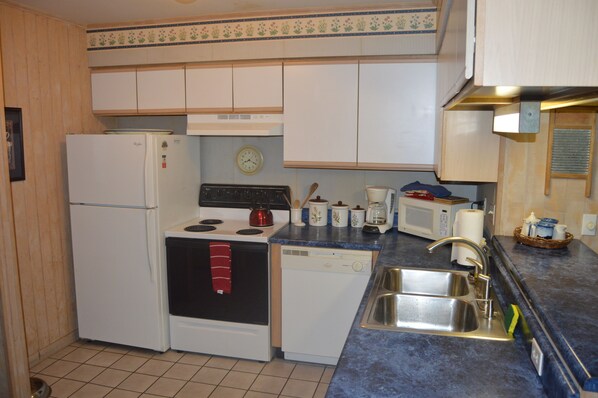 Fully functioning kitchen with fridge, stove and oven, dishwasher, kitchen ware