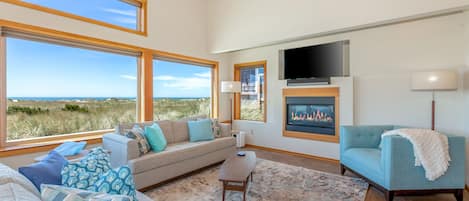 Living room with home theatre, including UHD smart tv, Apple TV, & Sonos system.