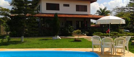 Vista frontal da casa com a piscina