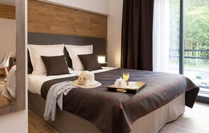 The bedroom features a plush double bed and big windows