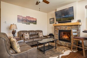 The living area features a gas fireplace, a flat-screen tv, Sonos sound system, and comfy furniture!