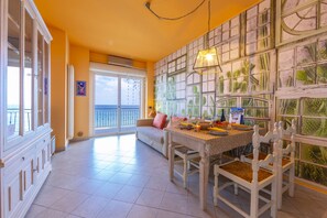 Living room with sofa, dining table and sea view