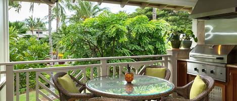 Lanai with table, chairs and built in bar-b-que with garden/pool view