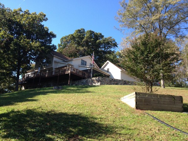 View of home coming up driveway. Home sits of hill with majestic views of nature