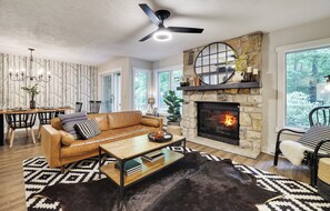 Relax on the buttery leather couch by the fire & enjoy a 65" TV with Sonos.