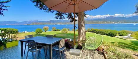 La terrasse avec accès direct à la pelouse, face à la mer et aux montagnes.