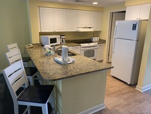 Kitchen with breakfast bar seating area/ stools.