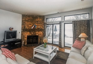 Cozy living room with wood burning fireplace and view of Lake Michigan.