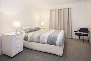 The downstairs bedroom is bright and comfortable, offering a queen-sized bed and a quiet space to rest.