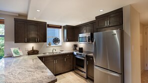 Well-equipped kitchen with granite counters, and stainless steel appliances