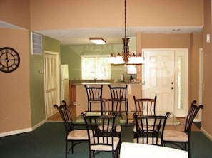 Dining area; kitchen in background; front entrance door.