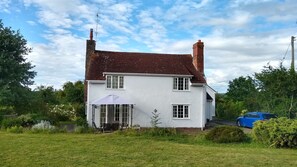 Front of house from lawn with summer gazebo over patio