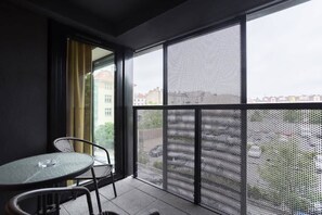 Furnished balcony with green surroundings. 