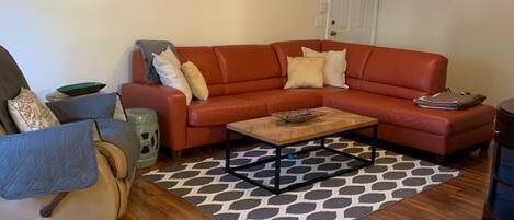 Main living room, leather couch with pull out bed, TV, + comfy rocking chair!