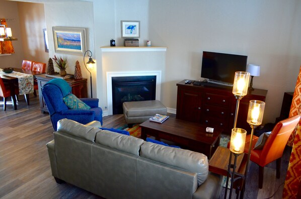 Living Room and Dining Area - The main level is open and spacious, with the living room area flowing into the dining room and fully equipped kitchen.