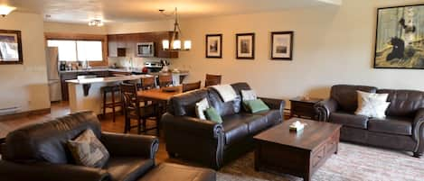 Living Room - The main level of this condo has an open layout with the living room area, dining room, and fully equipped kitchen. The living room area has two, comfortable sofas, one is a sofa sleeper, a TV, and a gorgeous stone fireplace.