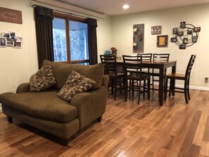 Dining room / living room. There is a tv mounted in front of the love seat. 