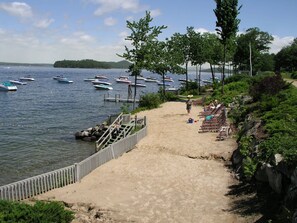 Samoset's private sandy beach with a pick up/drop off dock in the distance.