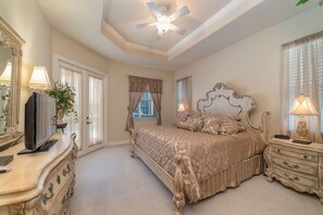 A lavish master suite with French doors beckoning you to the screened-in lanai with pool