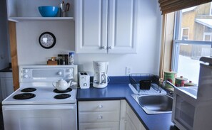 A bright kitchen stocked with dishes, cookware and other essentials