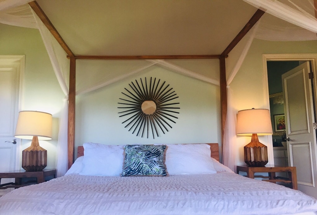Bedroom with poster-bed and sun-shaped mirror