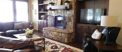 Cozy front room with rock fire place, tv and plenty of seating