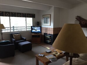 living room with TV and electronic fireplace looking out on Vail Mountain