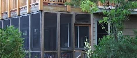 Upper deck faces ocean while lower screened-in porch is nestled in dunes.