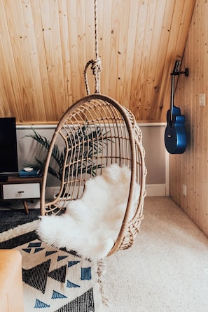 A relaxing egg chair hangs in the main living area