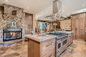 Viking range and double sided fireplace in kitchen