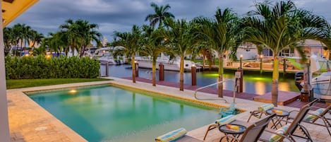 Colorful nigh time pool area set on an intracostal backdrop.