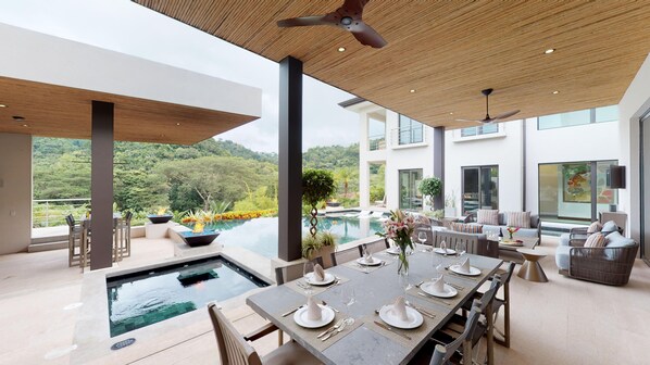 Open outdoor area, set up for entertainment. Dining area and an outdour kitchen with BBQ.