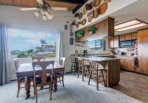 Dining area with wide windows and view of the ocean.