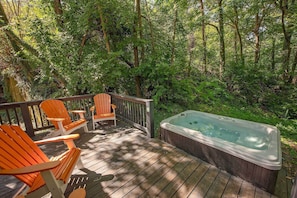 Private back deck with hot tub and seating.